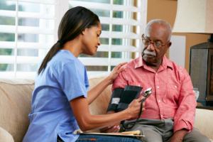caregiver checking blood pressure of an elderly man